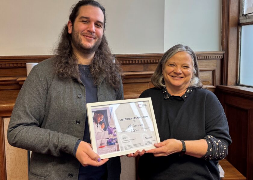 Ryan Harris from Cancer Research UK presents a certificate to Head of Wills & Probate Nicola Pugh